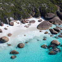 Aerial drone photography of turquoise water, granite boulders and white sand on a secluded WA south coast beach