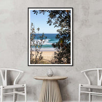 Black framed beach print, high-contrast Australian wall art of a turquoise wave framed by banksia branches at Ulladulla