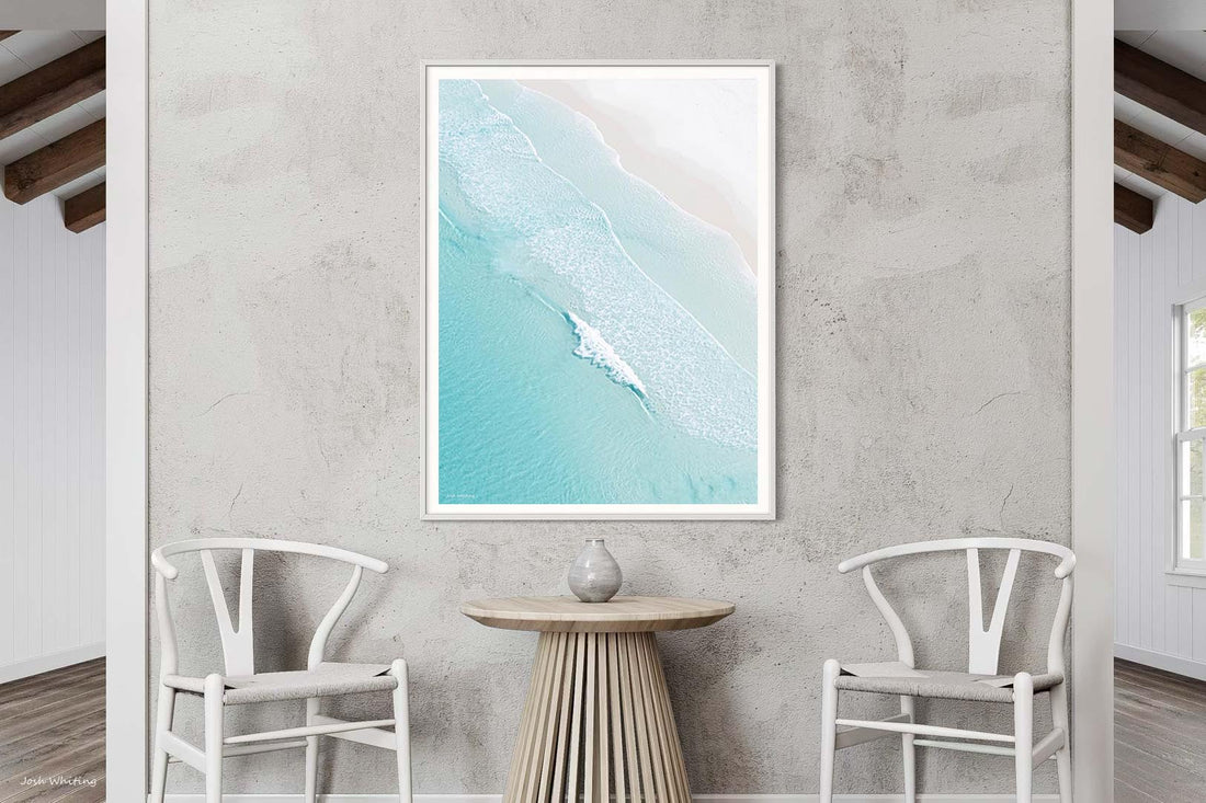 White framed print of Open Coast showing turquoise ocean and pale sand from above, coastal wall art for relaxed interiors