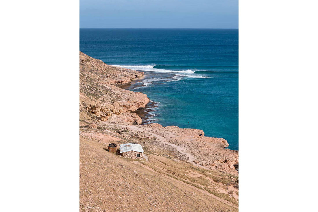 Red Bluff Quobba Station Western Australia - left hand point break peeling into deep turquoise Indian Ocean - lone stone shack on red hillside - Coral Coast fine art photography - Josh Whiting