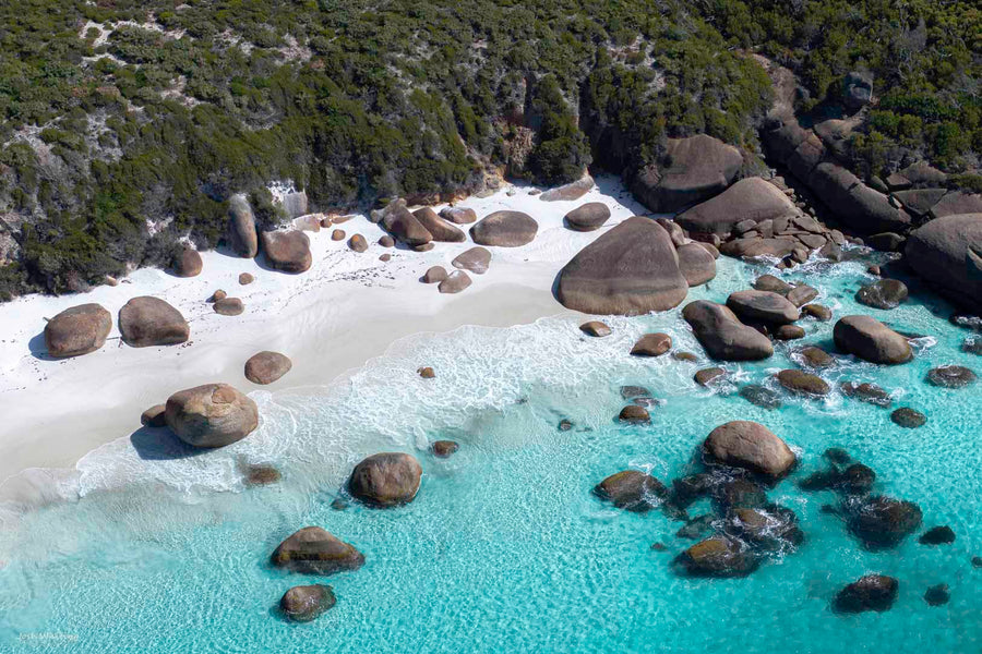 Aerial drone photography of turquoise water, granite boulders and white sand on a secluded WA south coast beach