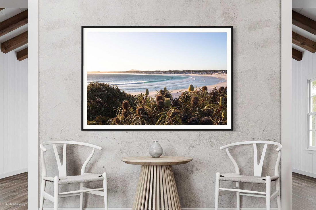 Black framed Wharton Beach print, bold contrast against the turquoise wave and pale sand